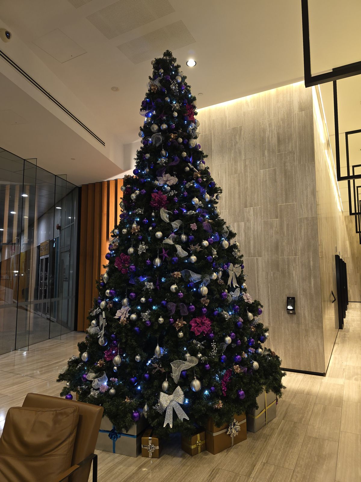 Purple and blue themed tree against marble in a premium lobby