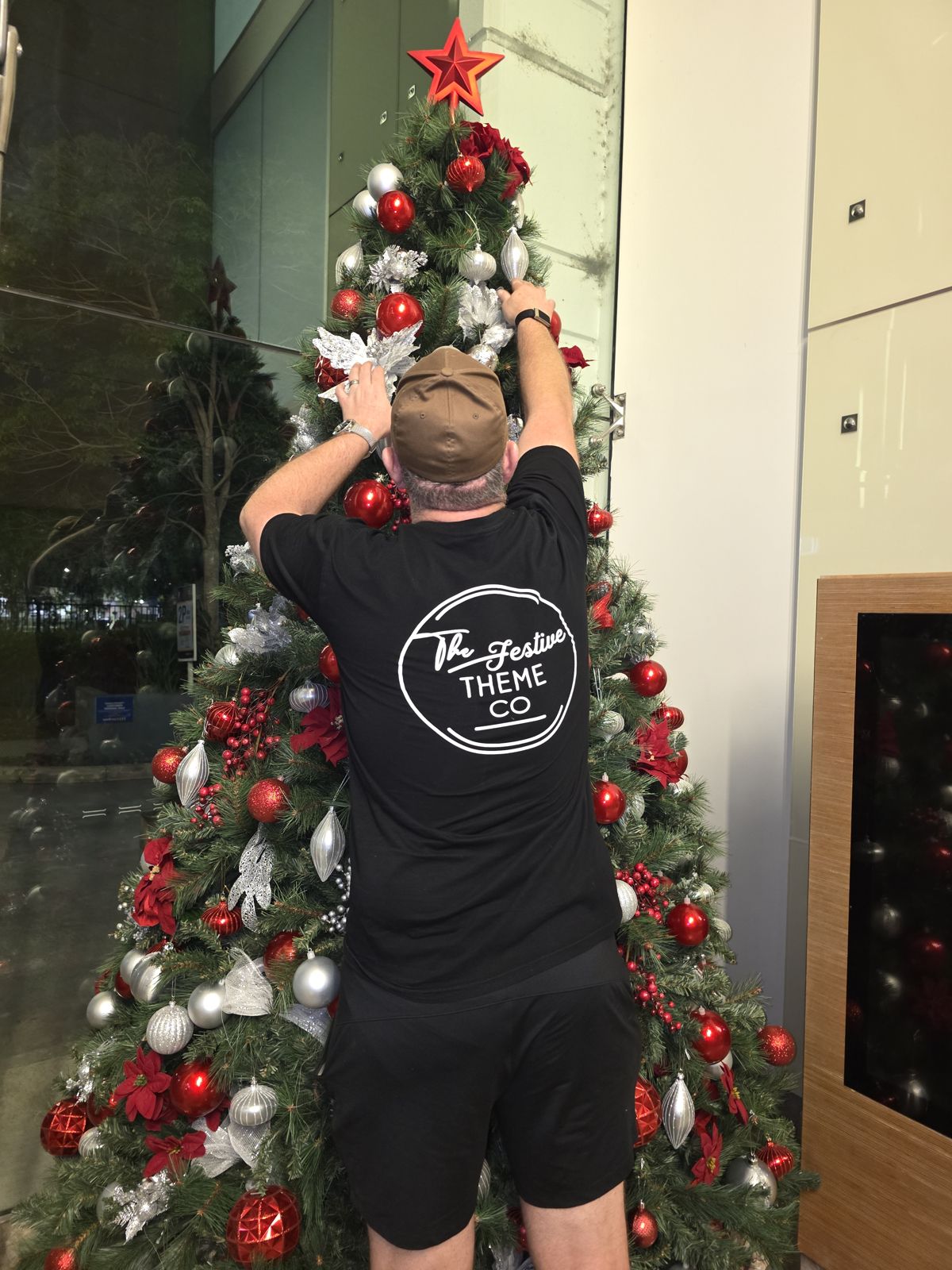 Festive Theme Co team member styling a Christmas tree