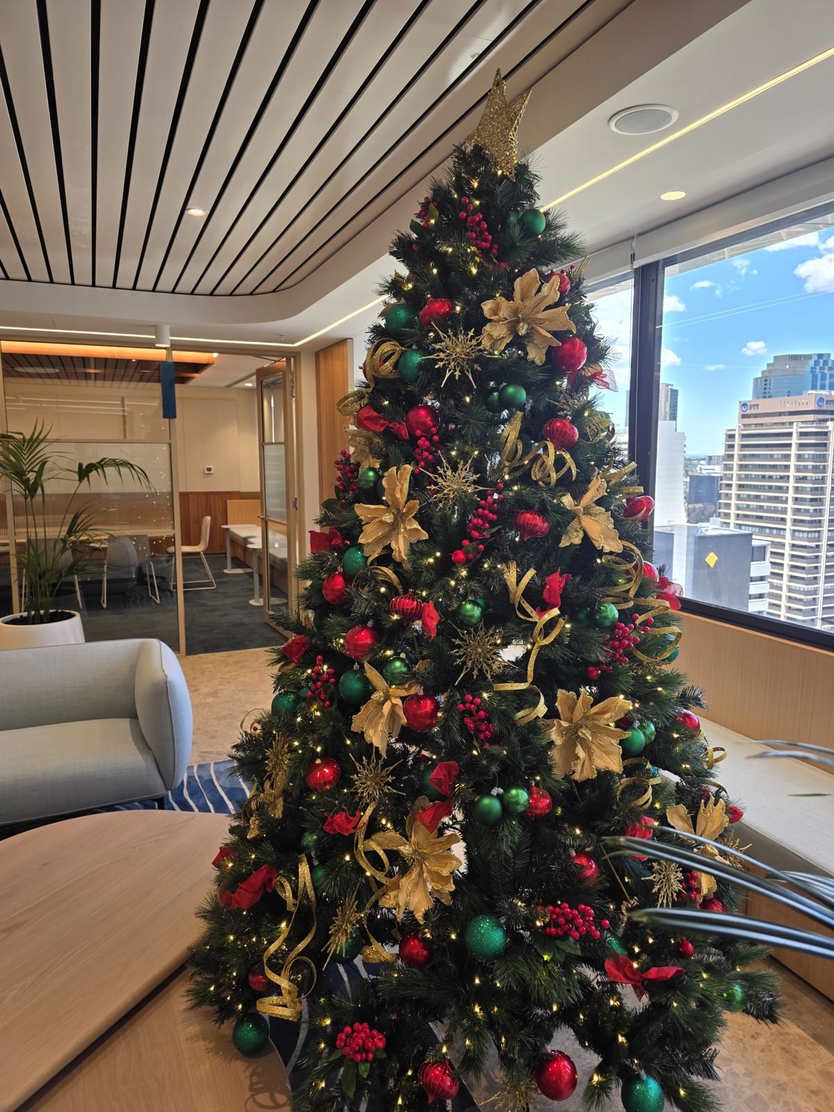 Red and gold Christmas tree in a Brisbane office with city views