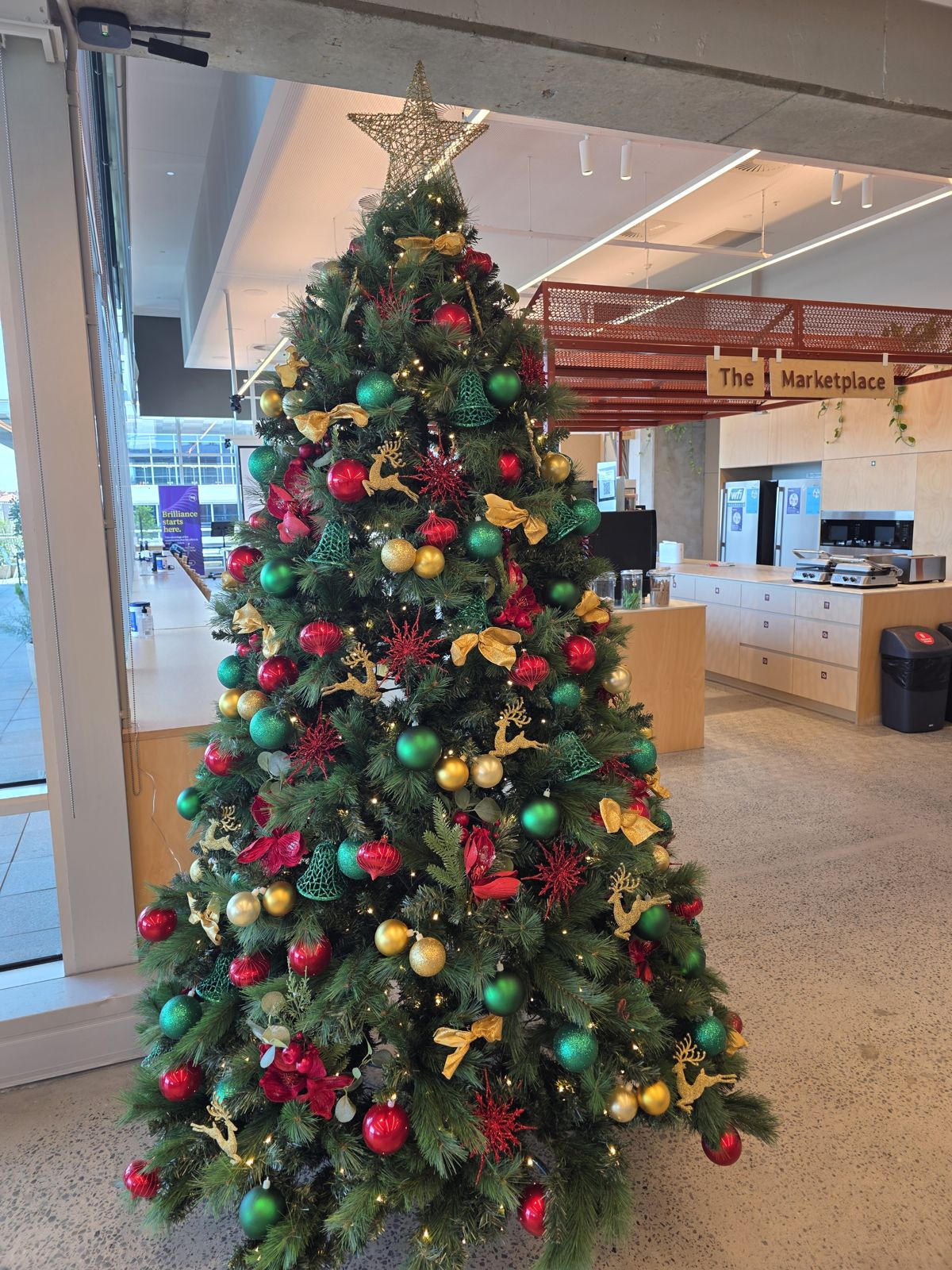 Red, green and gold tree in an office marketplace area