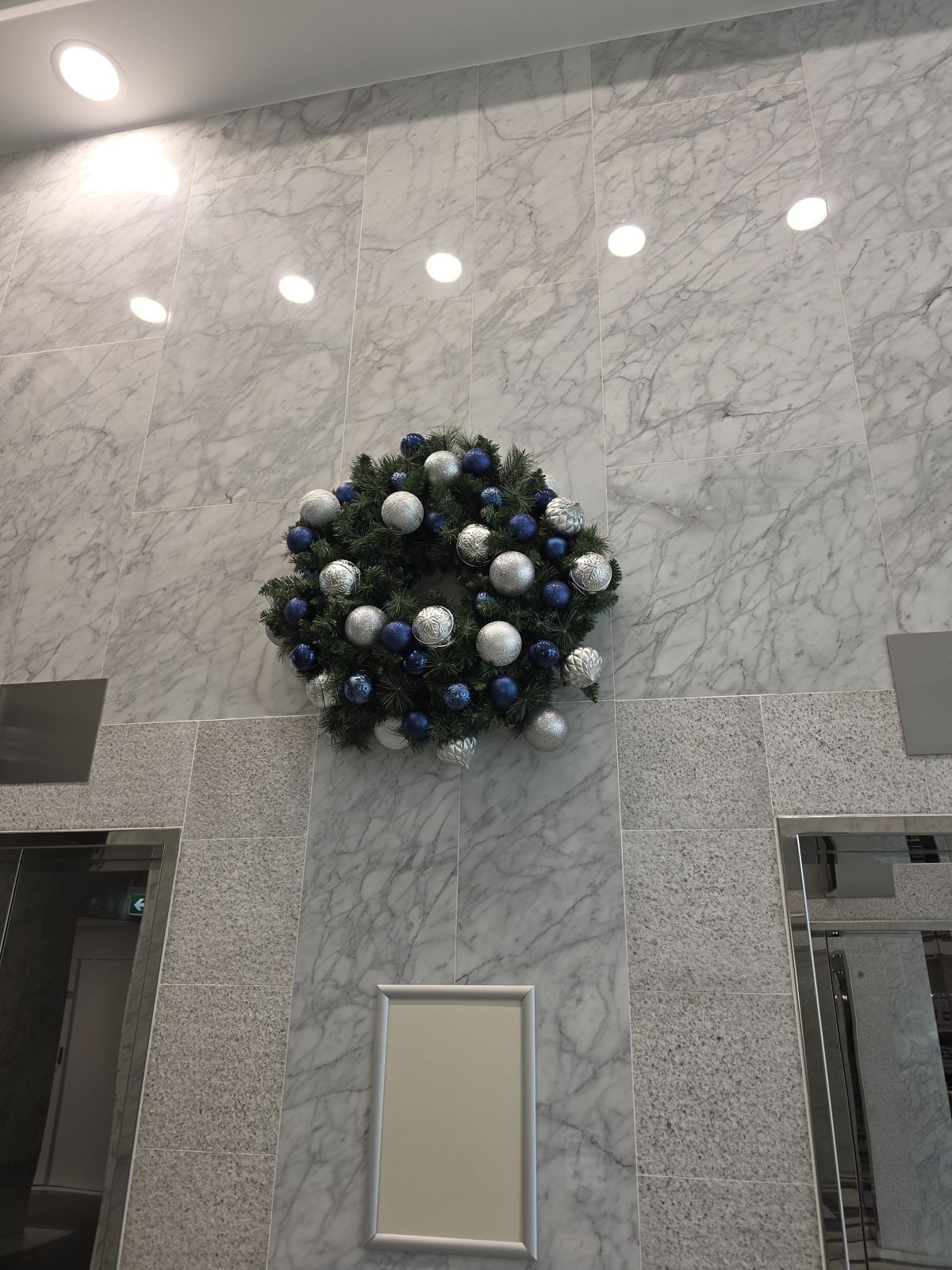 Blue and silver wreath on a marble lobby wall